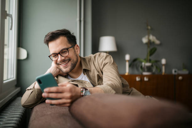 istock Happy young Caucasian man at home, using a smart phone 1336263938