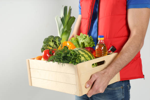 istock Courier with fresh products on light background, closeup. Food delivery service 1336264095