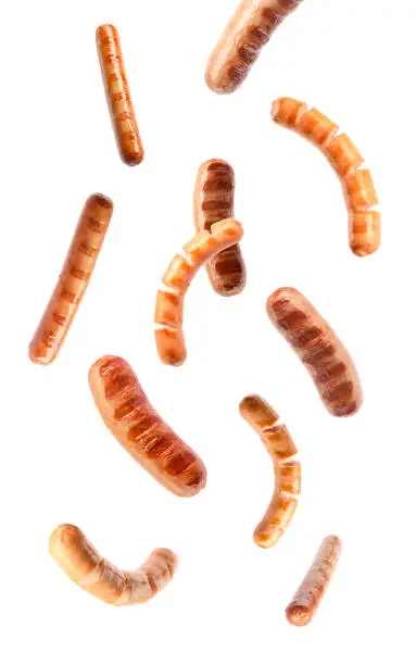 Flying delicious grilled sausages on white background