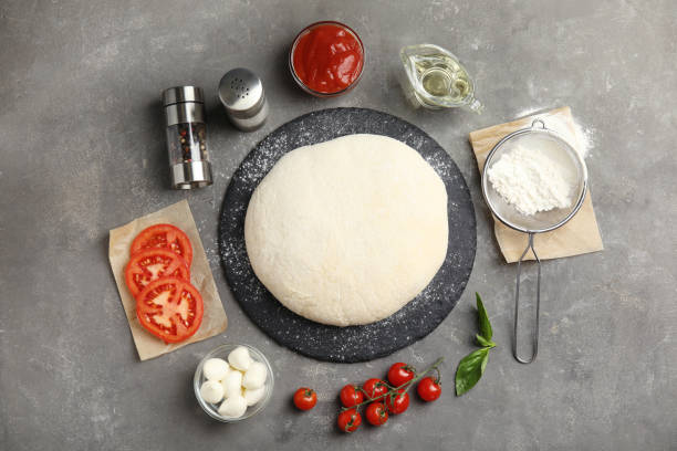 istock Flat lay composition with dough and fresh ingredients for pizza on grey table 1336264306