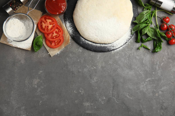 istock Flat lay composition with dough and fresh ingredients on grey table, space for text. Pizza recipe 1336265374
