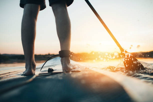 istock Close up of man paddleboarding at sunset 1336265655