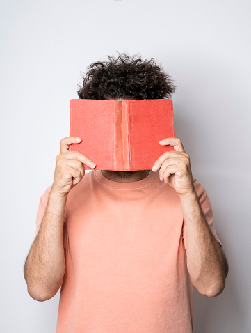 Man holding an old book to his face