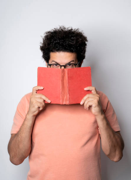 istock Man holding an old book to his face 1336267577