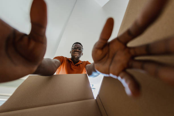 istock Smiling man unpacking things out of box 1336268721