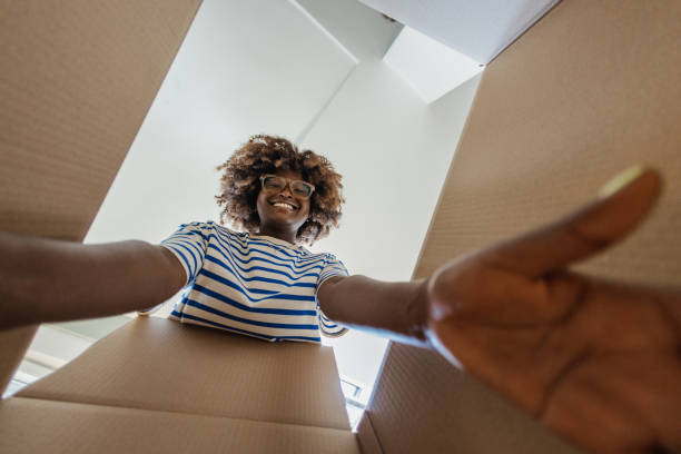 istock Smiling woman unpacking things out of box 1336268733