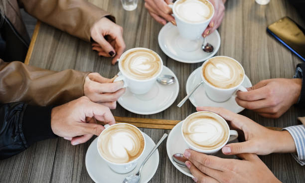 istock Group of people cheering with cappuccino cups inside coffee bar restaurant - Focus on bottom woman hands 1336270841