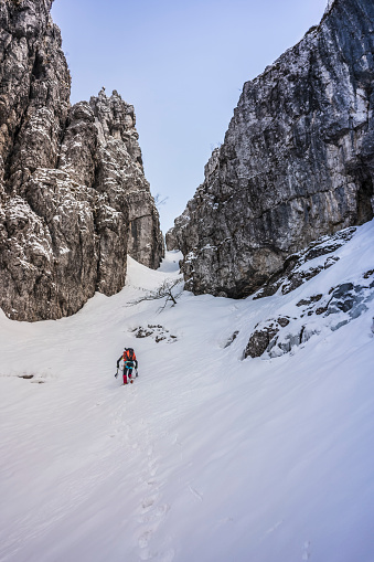 Solo hiker walking on a gully snowed