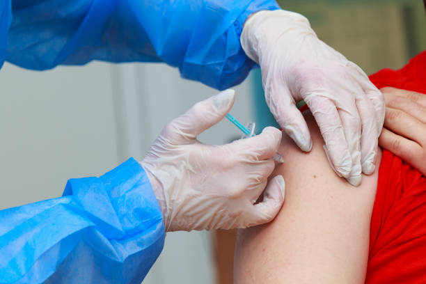 istock Syringe injection process on real coronavirus vaccination. Fighting the covid-19 pandemic. Selective focus , toned 1336271325
