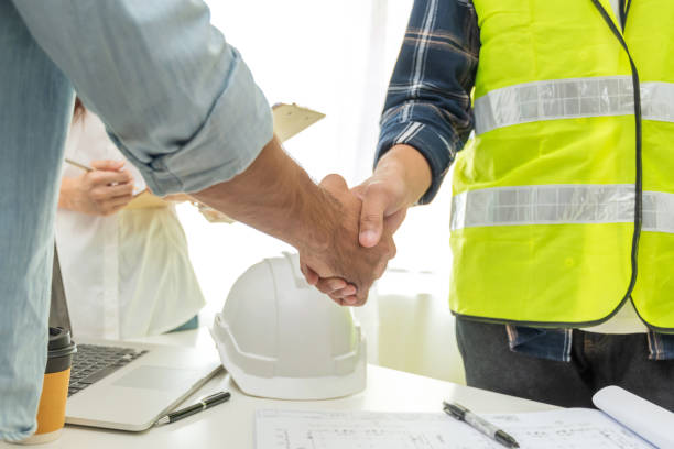 auftragnehmer handshake mit dem kunden nach geschäftstreffen start-up-projektvertrag auf der baustelle bürogebäude, geschäftspartnerschaft, engineering, kooperationsgeschäft und teamwork-konzept - safety meeting construction site construction stock-fotos und bilder