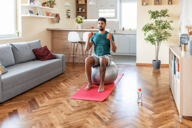 istock Healthy Black Man Doing Exercise On A Grey Pilates Ball With Weights 1336271786