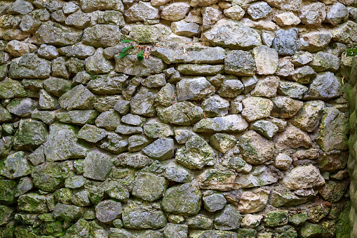 A wall of wild stone. Rough textured surface. Background for blank or graphic resource for design.