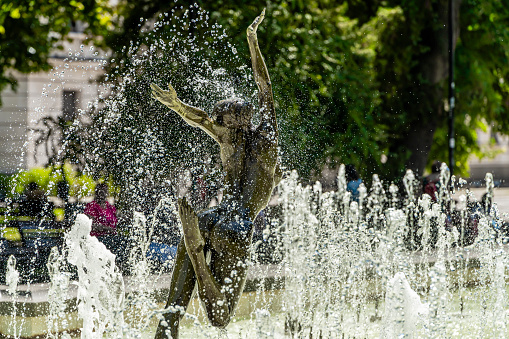 A detail of the beautiful Fountain of the Naiads in Piazza della Repubblica, in the heart of Rome, on the edge of the Rione Monti. The Fountain of the Naiads was built in 1870 during the pontificate of Pope Pius IX, a few days before the conquest of Rome by the troops of the Kingdom of Italy and the end of the temporal power of the papacy, by the artists Mario Rutelli e Alessandro Guerrieri. In the photo: In the foreground the figure of a Nymph, while behind the figure of Glaucus grabbing a dolphin, symbol of man's primacy over nature. The Monti district is a popular and multi-ethnic quarter much loved by the younger generations and tourists for the presence of trendy pubs, fashion shops and restaurants, where you can find the true soul of the Eternal City. The Rione Monti, located between Via Nazionale and the Fori Imperiali, is also rich in numerous churches in Baroque style and archaeological remains. In 1980 the historic center of Rome was declared a World Heritage Site by Unesco. Image in high definition quality.