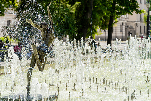 Cologne, Germany - Aug 14th 2022: A prominent fountain in Cologne is attracting people to chill out on a warm summer day.