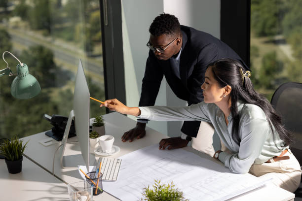 high angle view of a small diverse group of young colleague architects working together in their office - tenacidade imagens e fotografias de stock