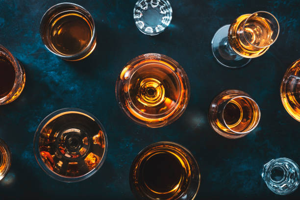 Strong alcohol drinks, hard liquors, spirits and distillates iset in glasses: cognac, scotch, whiskey and other. Blue background, top view stock photo