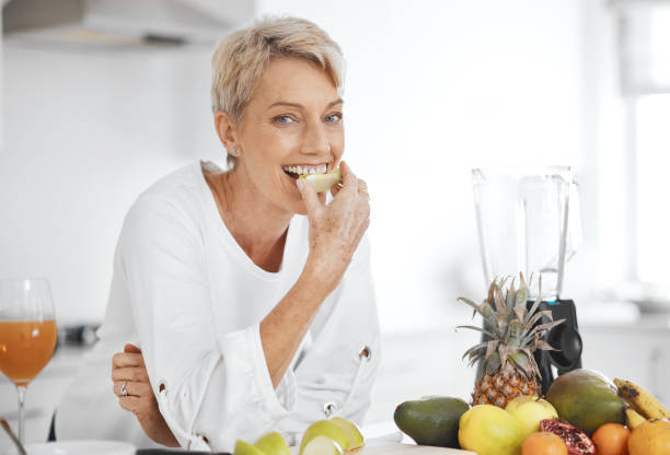 foto de una mujer comiendo fruta - tasting women eating expressing positivity fotografías e imágenes de stock