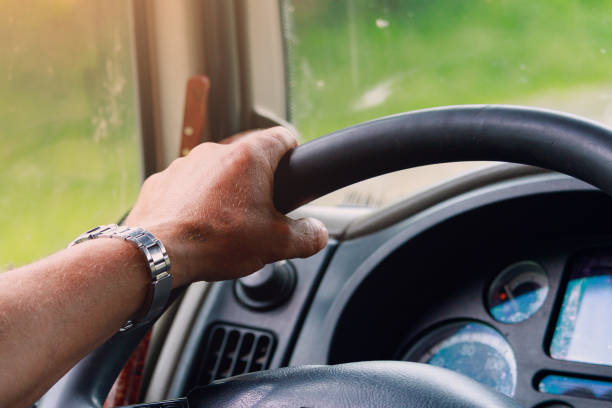 istock The hands of a professional driver on the steering wheel. Background with copy space for text 1336275880