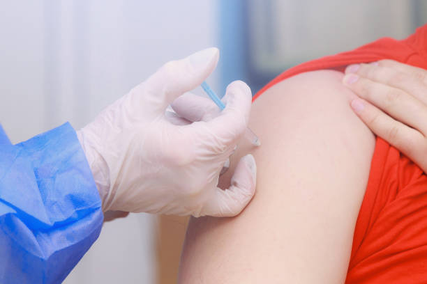 istock Syringe injection process on real coronavirus vaccination. Fighting the covid-19 pandemic. Selective focus , toned 1336283061