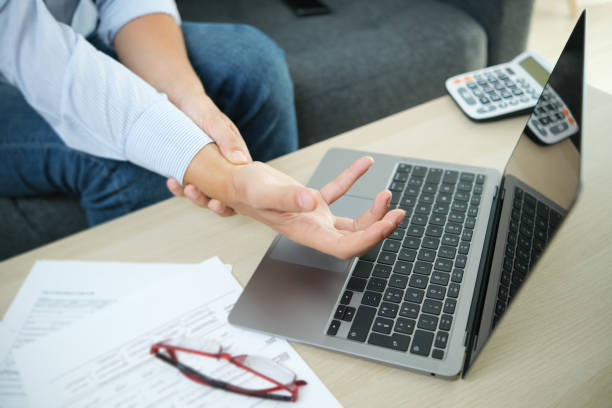 istock Man working from home with laptop feeling wrist pain 1336284996