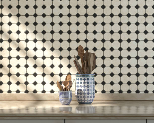 istock Front view kitchen with marble kitchen countertop and some wooden spoon sets on it under warm morning sunshine, ceramic small diamond tiles wall, 3d Rendering 1336285821