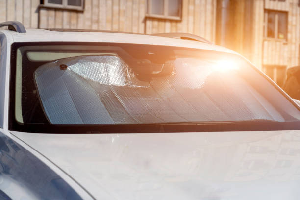 osłona przeciwsłoneczna lub reflektor przeciwsłoneczny na przedniej szybie samochodu chroni samochód na parkingu. na przedniej szybie świeci światło słoneczne - car sun screen window sunshade built structure zdjęcia i obrazy z banku zdjęć