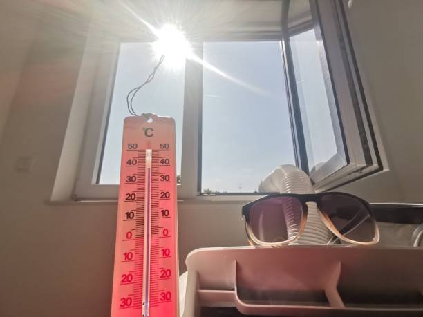 heißer sommertag mit fast 40 grad überleben mit tragbarer klimaanlage, sonnenbrille und thermometer - air conditioner window heat hot day stock-fotos und bilder