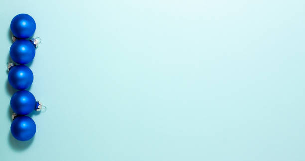 istock Blue Christmas balls on blue background on left side. Flat lay top view with copy space. Holidays concept 1336292719
