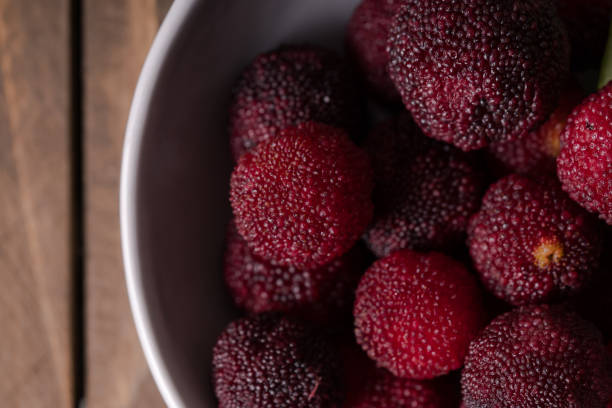 a bowl of bayberry fruit on a wooden plank