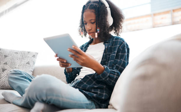 istock Shot of a young girl relaxing while using a digital tablet at home 1336297207