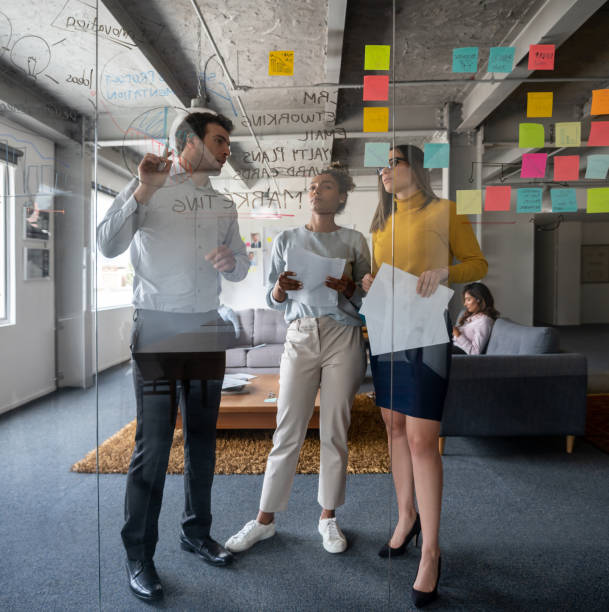 equipo de negocios discutiendo una estrategia de marketing en una reunión en la oficina - planning adhesive note business office fotografías e imágenes de stock