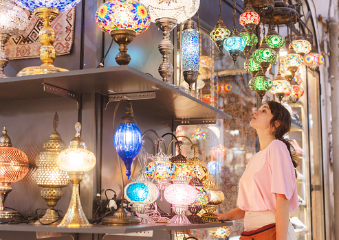 Young Caucasian woman choosing lamp on Grand Bazaar in Istanbul