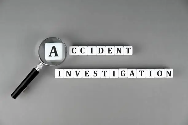 White cubes with text Accident Investigation with a magnifying glass