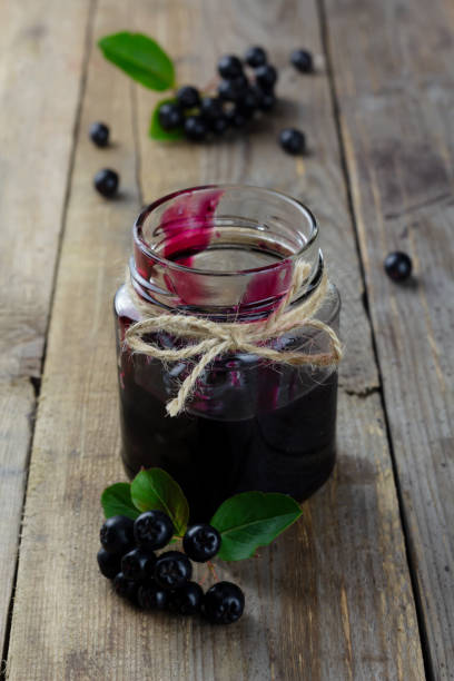 istock Chokeberry jam and fresh berries on wooden background 1336301827