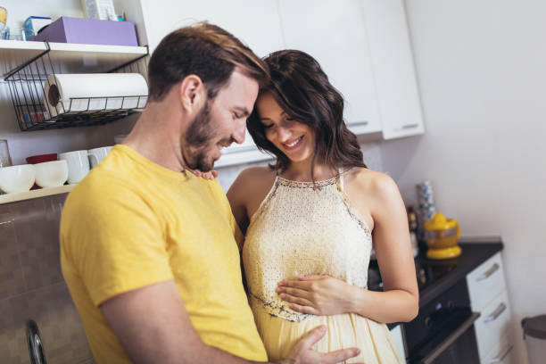 istock Pregnant woman with husband in the kitchen having fun. 1336303530