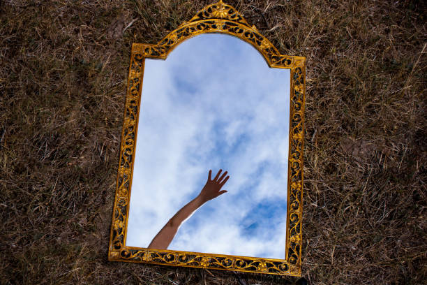 istock Vintage mirror reflecting hand and blue sky 1336306904
