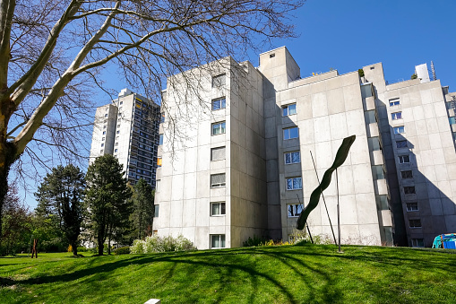 Bern, Switzerland - April 20, 2019: Among trees and plants there is a housing estate and concrete multi-family buildings. It is the residential district of Murifeld \