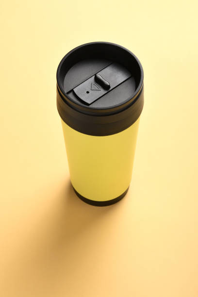 断熱飲料容器、コピースペース付き黄色の背景にコーヒーマグカップ - 5599 ストックフォトと画像