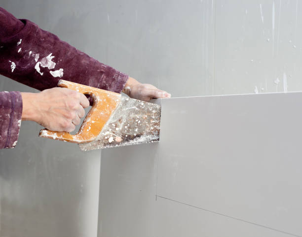 istock cutting plasterboard plaster hand dirty saw 1336308700