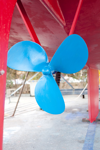 blue sailboat propeller in a red painted hull