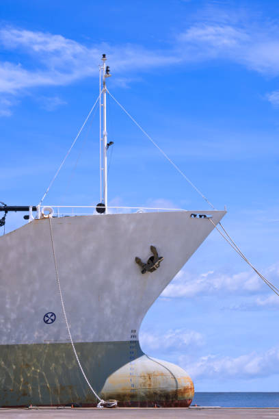 istock Cargo ship moored at port against white clouds on blue sky background 1336311553