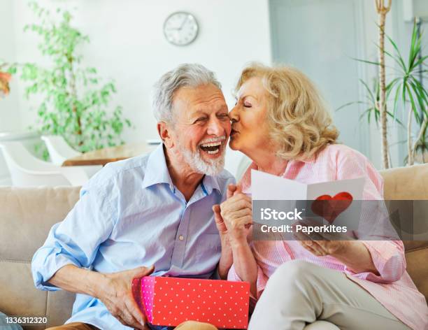 Gift Woman Man Couple Happy Love Happiness Present Kiss Romantic Smiling Together Box Wife Husband Elderly Old Senior Mature Retired Stock Photo - Download Image Now