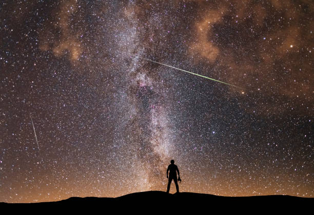 hermosa noche estrellada, silueta de fotógrafo con cámara mira a la vía láctea. paisaje nocturno, fondo astronómico. - silhouette kissing park sunset fotografías e imágenes de stock