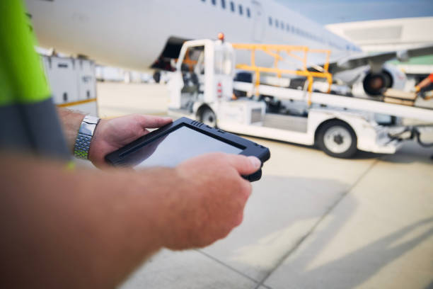 istock Member of ground staff using tablet against plane at airport 1336314030