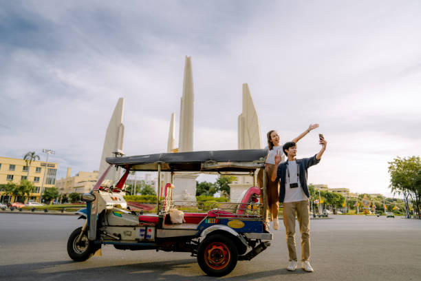 traveler couple enjoying a landmark in city. while taking a selfie around car - jinrikisha imagens e fotografias de stock