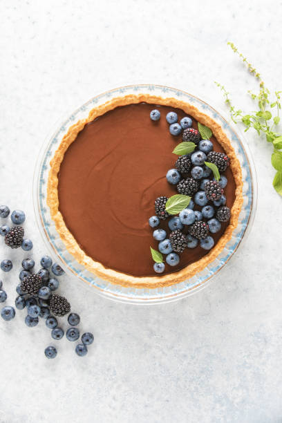 istock Dark chocolate mousse tart decorated with fresh blueberries and the mint, view from above 1336317080