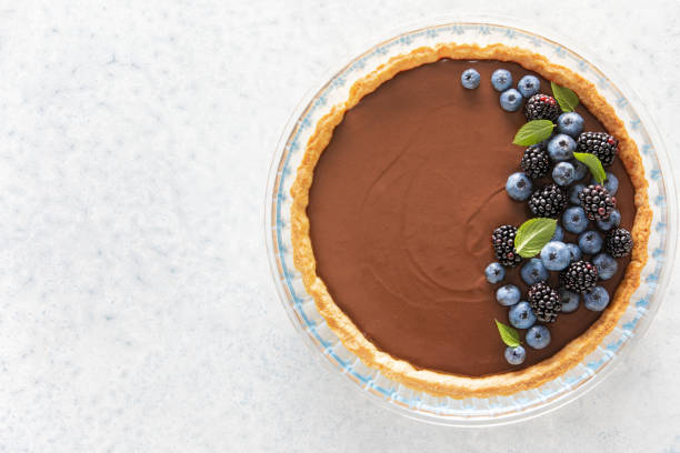 istock Dark chocolate mousse tart decorated with fresh blueberries and the mint, view from above 1336317103