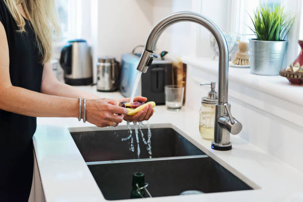 istock Close-up on woman's hands washing vegetables in home kitchen. 1336318681