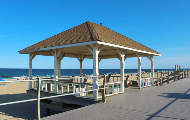 istock Well-kept pavilion with benches on boardwalk in front of beach (sand and shore) 1336318756