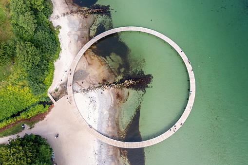 Aarhus, Denmark - August 25, 2021: The Infinite Bridge has been created by architect Niels Povlsgaard and Johan Gjødes. Originally, The Infinite Bridge was displayed in relation with the Sculpture By The Sea event in 2015. The people of Aarhus took to the work of art to such an extent that the Municipality of Aarhus contributed to reconstructing the bridge as a permanent piece of art.